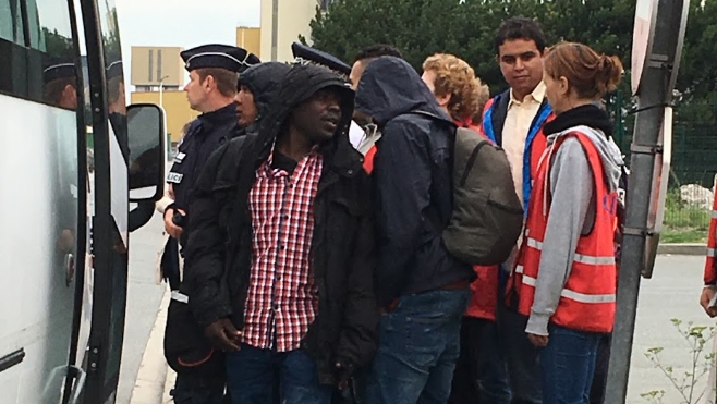 Deux bus emmènent quelques migrants de Calais vers le centre d'accueil de Troisvaux.