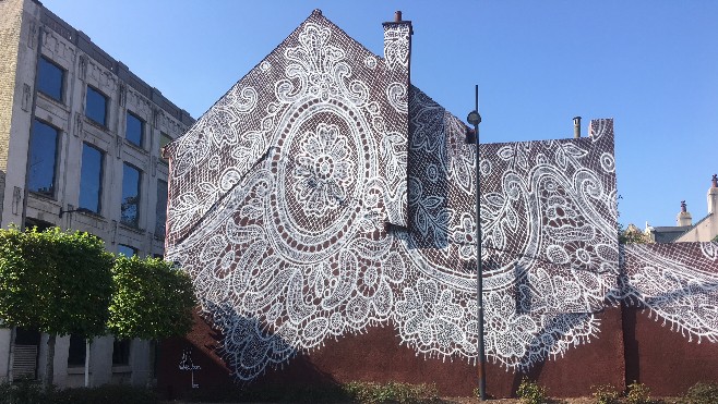 Motif géant de dentelle sur le mur d’une ancienne maison de tulliste à Calais